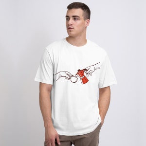 Puede incluir: Camiseta blanca con un gráfico de dos manos, una vertiendo café de una cafetera Moka roja y blanca en una taza sostenida por la otra mano.