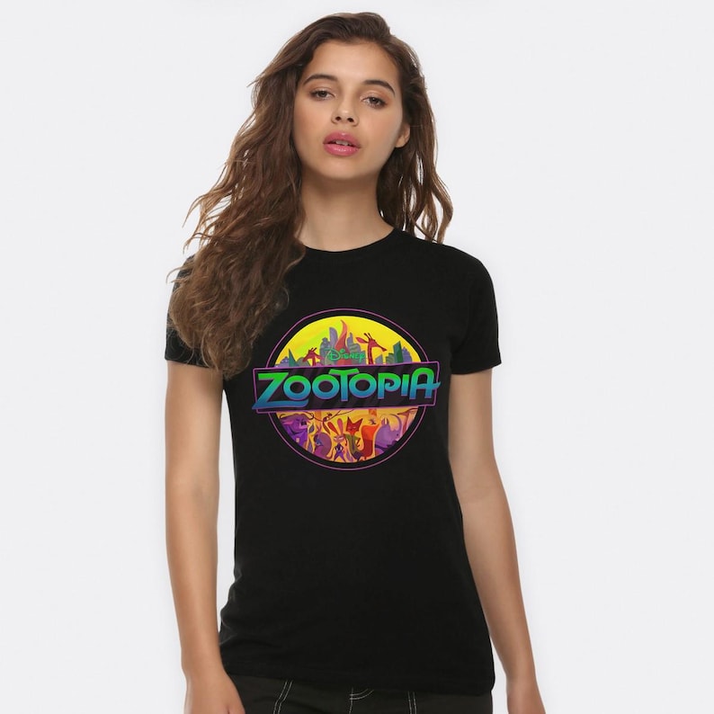 May include: Black t-shirt with a retro-style graphic of the Zootopia skyline and the text "Zootopia" in a rainbow gradient.