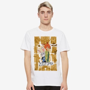 May include: White t-shirt with a graphic print of the characters Judy Hopps and Nick Wilde from the movie Zootopia. The graphic is a collage of images from the movie, including a giraffe, a sloth, and a fox. The text "Zootopia" is printed in black letters below the characters.