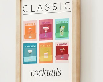 May include: A framed print with the word "CLASSIC" in black text at the top. Below the word "CLASSIC" are six colorful squares, each with a different cocktail illustration and name. The cocktails are: Spritz, Marg, Mojito, Martini, Mai Tai, and Cosmo. The bottom of the print says "cocktails" in black text.
