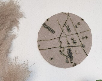 Framed hand embroidery artwork in rustic beige linen, black waterbased paint and gold thread . Universe path Collection Nº2