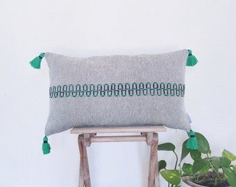 Modern home pillow cover with tassels and embroidery design in black and emerald green over a cotton plain weave pattern in black & beige.