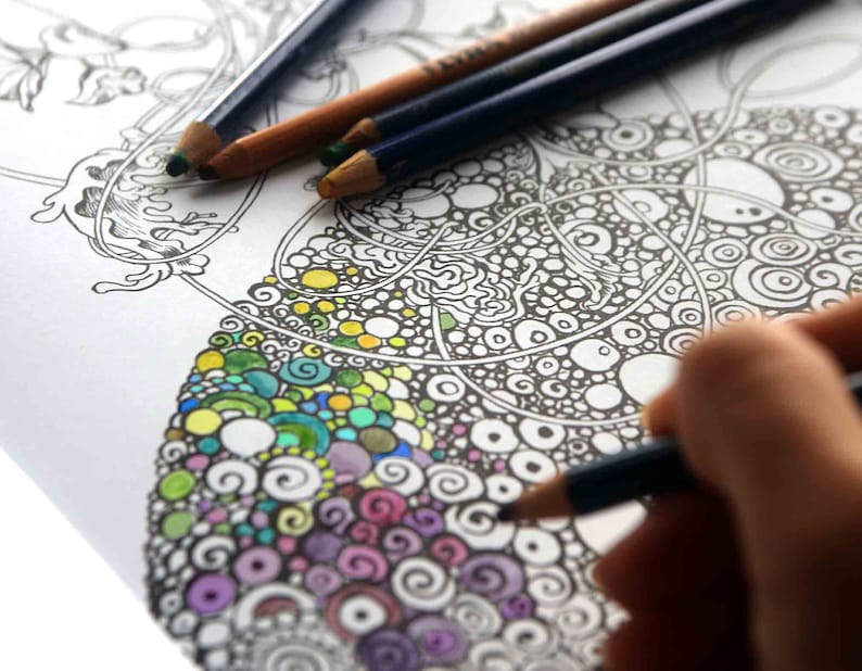 K&ouml;nnte beinhalten: Nahaufnahme einer Person, die ein detailliertes Schwarz-Wei&szlig;-Mandala-Design mit Buntstiften ausmalt. Das Design enth&auml;lt komplizierte Wirbel, Kreise und Punkte. Die Person verwendet einen blauen Stift, um das Design auszumalen.