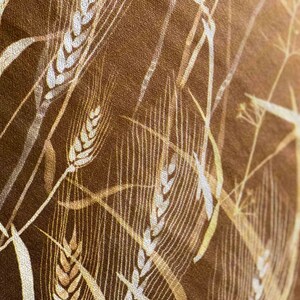 May include: A close-up of a brown fabric with a white wheat pattern. The fabric has a textured surface and a subtle sheen.
