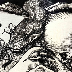 May include: Black and white illustration of a snake wrapped around two hands, with flowers and leaves in the background.