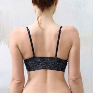 May include: A black and white patterned sports bra with thin adjustable straps.