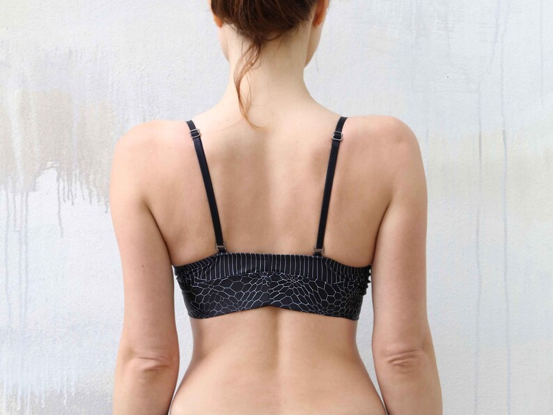 May include: A black and white patterned sports bra with thin adjustable straps.