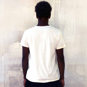 May include: A plain white t-shirt with short sleeves. The shirt has no design or text.