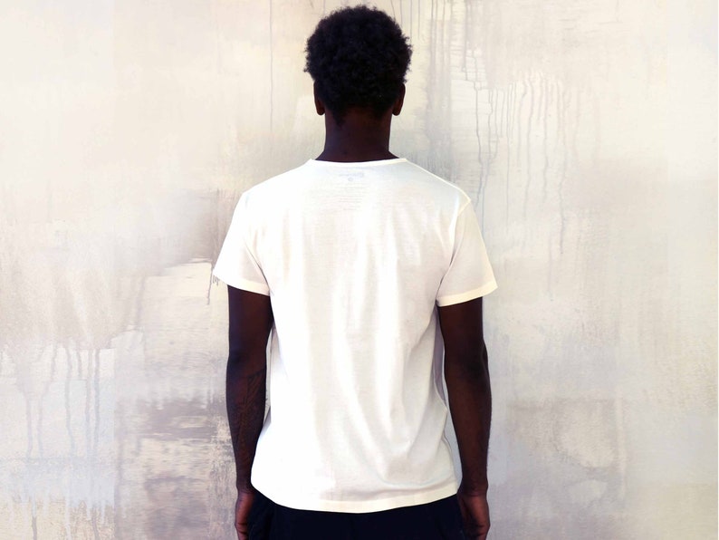 May include: A plain white t-shirt with short sleeves. The shirt has no design or text.