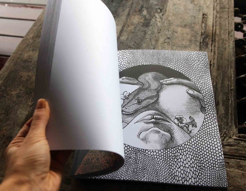 K&ouml;nnte beinhalten: Eine Schwarzwei&szlig;illustration einer Schlange, die sich um eine Hand mit Blumen windet. Die Illustration befindet sich auf einer Buchseite mit einem schwarz-wei&szlig;en Muster im Hintergrund.