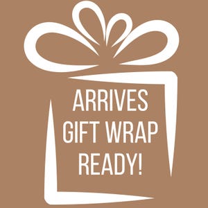 Pu&ograve; includere: Una grafica quadrata marrone che presenta il contorno bianco di una scatola regalo con un fiocco sopra. Il testo all'interno della scatola recita ARRIVES GIFT WRAP READY! in lettere maiuscole bianche su uno sfondo marrone a tinta unita.