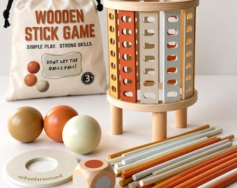 Op de afbeelding: Een houten stokjesspel met een cilindrische toren met oranje, crème en beige latten, een beige tas met de tekst "WOODEN STICK GAME", drie gekleurde ballen, een houten dobbelsteen, een ronde basis en diverse dunne gekleurde stokjes.
