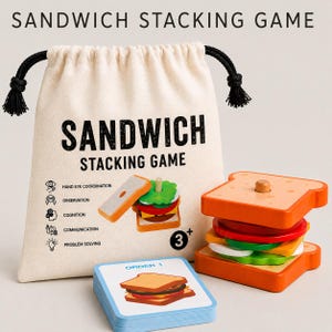 Pu&ograve; includere: Un gioco di impilamento sandwich in legno con un sacchetto beige con coulisse stampato con il testo SANDWICH STACKING GAME, pezzi di ingredienti per sandwich e un mazzo di carte etichettato ORDER 1 con un'illustrazione di un sandwich.