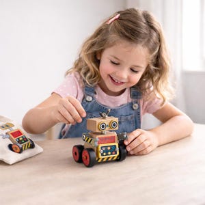 May include: A small wooden robot toy featuring a light brown head with two circular eyes, a red chest panel with colorful geometric shapes, and black wheels with red centers. The robot has yellow and black hazard stripes along the base.