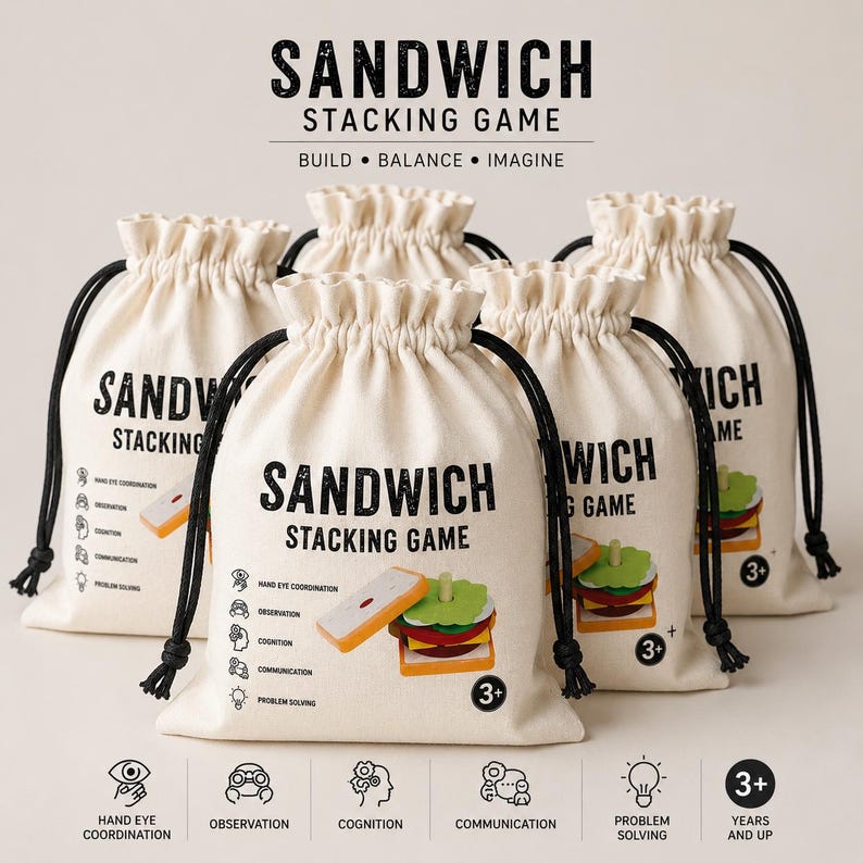 Pu&ograve; includere: Cinque sacchetti con coulisse in tela color bianco sporco per un gioco di impilamento di panini. Ogni sacchetto riporta il testo SANDWICH STACKING GAME, l'illustrazione di un panino giocattolo e icone per coordinazione occhio-mano, osservazione, cognizione, comunicazione e risoluzione dei problemi, oltre a un'indicazione di et&agrave; 3+.