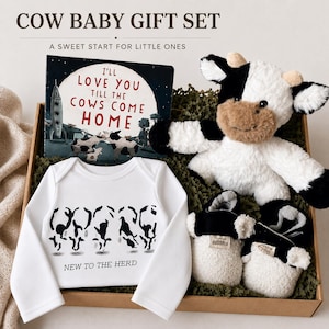 May include: A cow-themed baby gift set includes a plush cow, a onesie with a cow graphic, a book titled "I'll Love You Till The Cows Come Home", and cow-print baby booties. The onesie reads "New to the Herd". The set is presented in a brown box.
