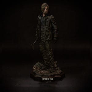 May include: A detailed figurine of a character from Resident Evil, standing on a rocky base. The figure wears a black leather jacket, pants, and gloves, holding a weapon. The base has the text "RESIDENT EVIL requiem."