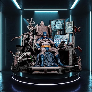 Op de afbeelding: Een gedetailleerd Batman-actiefiguur zittend op een complexe, donkere mechanische troon. Het figuur draagt een grijs en blauw pak met een gele gereedschapsriem. De troon is voorzien van meerdere computerschermen met kaarten en gegevens.
