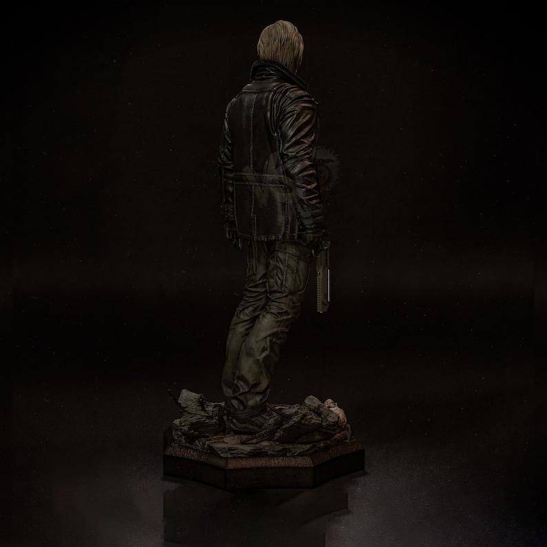 May include: A detailed figurine of a person in a black leather jacket and pants, holding a knife. The figure stands on a rocky base with a dark background. The figure is facing away from the viewer.