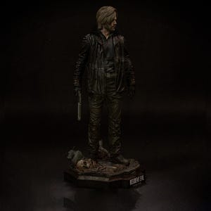May include: A detailed figurine of a character from Resident Evil, dressed in a black leather jacket and pants, holding a silver pistol. The figure stands on a base with the game's logo. The figure has blonde hair and is looking to the side.