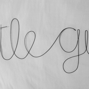 May include: Wire art sculpture of the words "little guy" in a cursive font.
