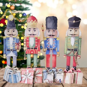 May include: Four watercolor nutcracker figurines with different colored uniforms and hats. Each figurine is holding a different accessory, such as a sword, a drum, a staff, and a gift. The figurines are standing on top of small gift boxes with ribbons.
