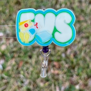 May include: A badge reel with the letters "EVS" in white, outlined in teal, with a teal border. The badge reel has a cartoon illustration of cleaning supplies. The reel has a silver clip and a purple accent.