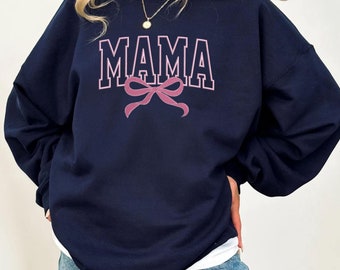 May include: A navy blue sweatshirt with the word "MAMA" printed in white with a pink bow underneath.