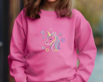 May include: A pink sweatshirt with a colorful unicorn and stars design. The unicorn is facing left and has a rainbow mane and tail.