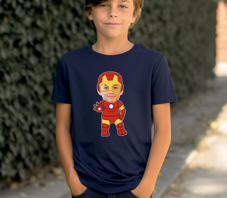 K&ouml;nnte beinhalten: Ein marineblaues T-Shirt mit einem Cartoon-Bild von Iron Man, auf dessen Gesicht das Gesicht eines Kindes &uuml;berlagert ist.