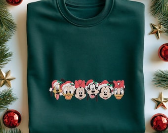 May include: A dark green crewneck sweatshirt featuring a horizontal graphic of six cartoon characters wearing red and white Santa hats with holly accents. The characters include Pluto, Donald Duck, Minnie Mouse, Goofy, Mickey Mouse, and Daisy Duck.