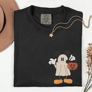 Pu&ograve; includere: T-shirt nero Comfort Colors con un design di Mickey Mouse fantasma a tema Halloween. La grafica ricamata presenta Mickey in costume da fantasma che tiene in mano un secchio a forma di zucca. Una collana con pendente a stella dorata &egrave; drappeggiata sulla maglietta.