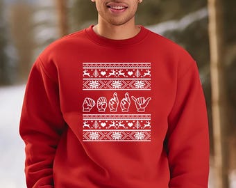 May include: A red sweatshirt with a white design featuring snowflakes, hearts, reindeer, and the word "Daddy" spelled out in American Sign Language. The design is centered on the chest.