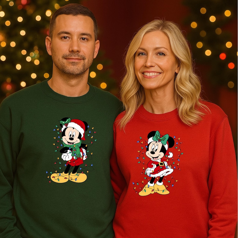 K&ouml;nnte beinhalten: Zwei Personen tragen passende Weihnachtspullover. Einer ist dunkelgr&uuml;n, der andere rot. Jeder Pullover zeigt eine Cartoonfigur mit Weihnachtsm&uuml;tze und Lichterketten. Der Hintergrund ist ein Weihnachtsbaum.