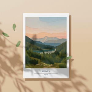 May include: Watercolor print of a mountain landscape with a lake. The artwork features layers of green, blue, and orange hues, with the text "SERVUS Bayern" at the bottom. The print is on a white background.