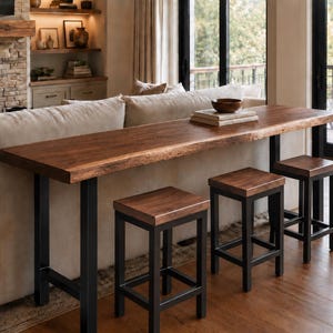 May include: A long, rectangular console table with a natural live-edge wood top and black metal legs, accompanied by three matching square stools with wooden seats and black metal frames, positioned behind a beige sofa in a living room setting.