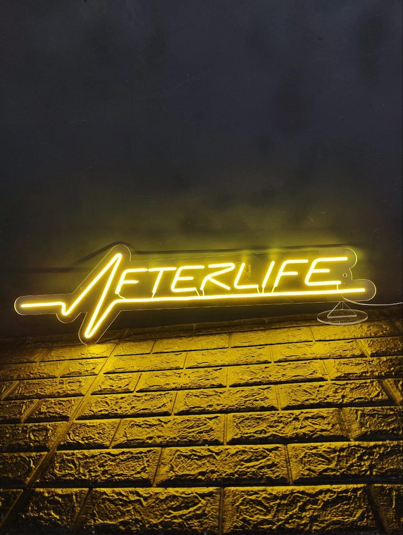 Afterlife LED neon sign for game room decor, bedroom wall art, or bar ambiance. This light-up sign captures a sleek cyberpunk aesthetic, making it an ideal gift for fans of Cyberpunk 2077 or modern sci-fi design. Perfect for man caves, gaming setups