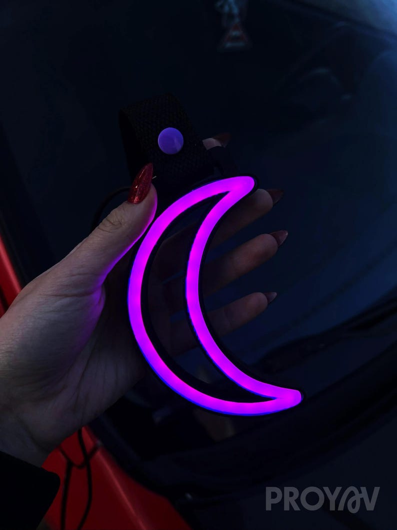 Neon Moon Tsurikawa car handle decor styled in a cozy vehicle interior, perfect for night drivers, car guys, and unique decor lovers. Works beautifully in cars or rooms, adding a relaxing, dreamy glow that feels peaceful, aesthetic, and visually captivating.
