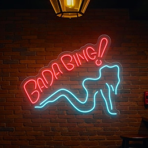 Bada Bing neon sign with bright LED glow in a retro style, perfect for bar decor, game rooms, man caves, or bedroom wall accents. Adds a fun and iconic pop culture vibe to any space.