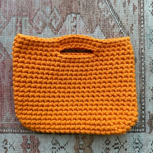 Orange crocheted top handle clutch tote