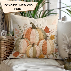 May include: A square throw pillow featuring a faux patchwork print of three pumpkins in shades of orange, beige, and sage green. The pumpkins are decorated with various patterns including gingham and floral motifs, surrounded by autumn leaves and sprigs.