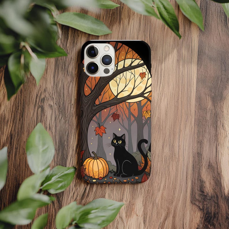 May include: A black phone case featuring a Halloween-themed illustration. The design includes a black cat, a pumpkin, and a forest scene with a full moon and autumn leaves. The case is designed to fit a smartphone.