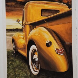 May include: A vintage yellow pickup truck with a whitewall tire, a red taillight, and a sunset in the background.