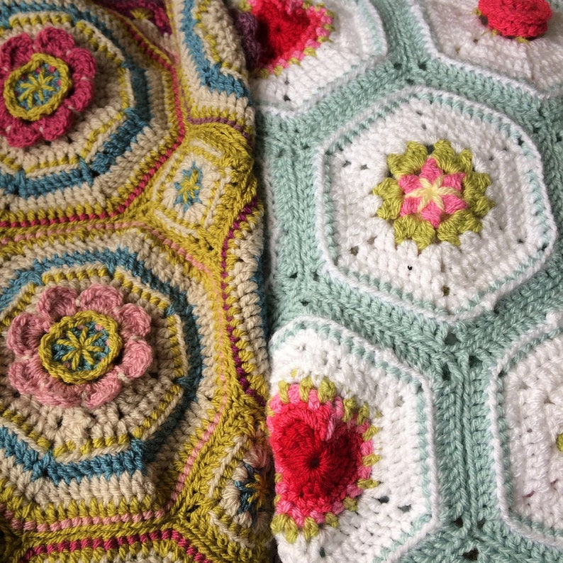 May include: Two crocheted blankets with floral patterns. One blanket is green, white, and pink. The other blanket is yellow, brown, blue, and pink.