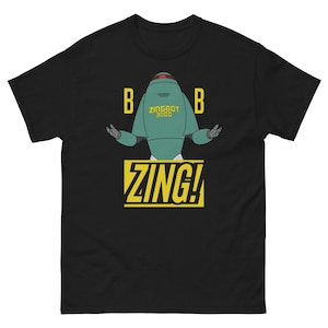 May include: A black short-sleeve t-shirt featuring a graphic of a teal robot with the text ZINGBOT 3000 on its chest. The letter B is on both sides of the robot, and the word ZING! is printed in large yellow letters inside a yellow box below.
