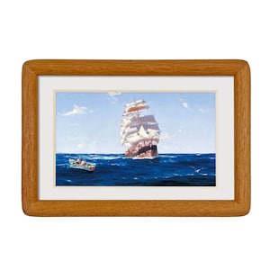 May include: A framed painting of a ship with white sails sailing on a blue ocean. A small boat with people in it is in the foreground.