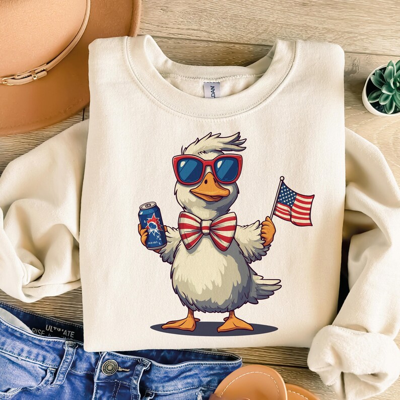 May include: A white duck wearing red sunglasses and a red, white, and blue bow tie holds a can of beer in one hand and a small American flag in the other. The duck is standing on a white background.