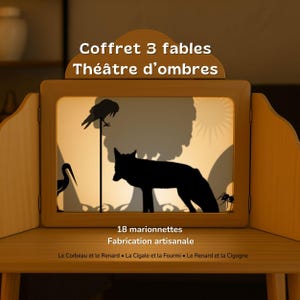 May include: Wooden shadow theater with a backlit screen displaying silhouettes of a crow, wolf, and other figures. The text "Coffret 3 fables Théâtre d'ombres" is at the top. The set includes 18 marionettes.