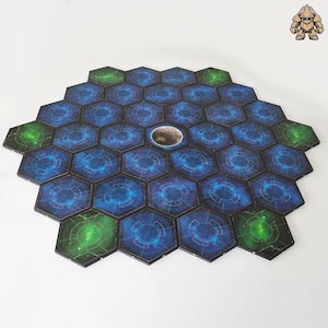 Puede incluir: Un tablero de juego hexagonal con 27 fichas. Las fichas son azules con un patrón de galaxia y un círculo brillante en el centro. Hay 6 fichas verdes con un patrón de galaxia y un círculo brillante en el centro. Las fichas están dispuestas en un círculo alrededor de una ficha central con una imagen de la luna.