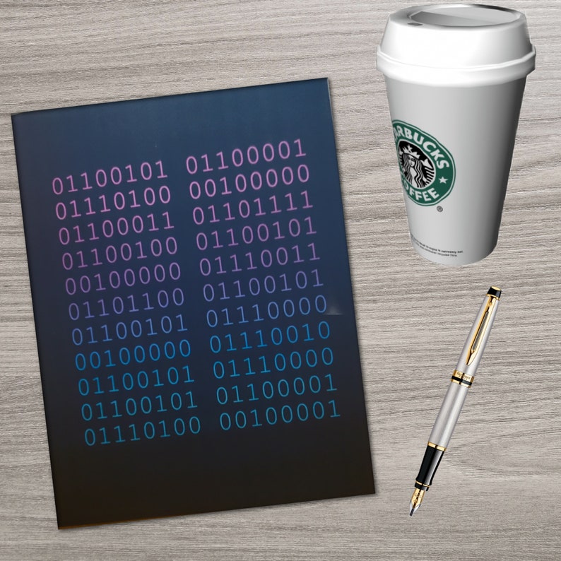 K&ouml;nnte beinhalten: Ein dunkelblaues Notizbuch mit einem Muster aus bin&auml;rem Code in Rosa und Blau. Der Code wird in Zeilen und Spalten wiederholt. Das Notizbuch liegt auf einer hellbraunen Holzoberfl&auml;che mit einem Stift und einer Kaffeetasse.
